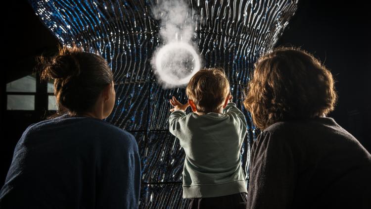 Family looking at vapour ring from Infinity Blue sculpture