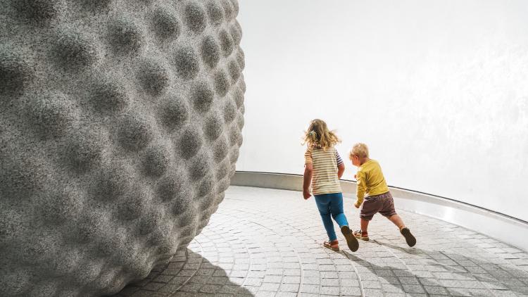 Kids running around Seed sculpture
