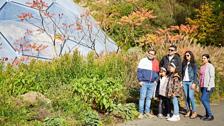 Family enjoying autumn colour with Eden's Biomes in the background