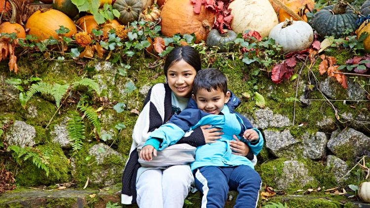 Two children posing in front of pumpkin display