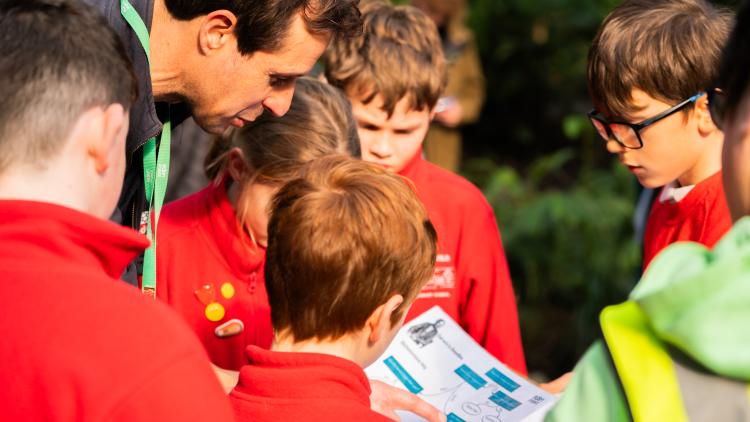 Group of school kids with educator looking at a leaflet