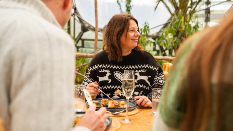 Lady sat at table eating Mediterranean Biome Christmas Lunch