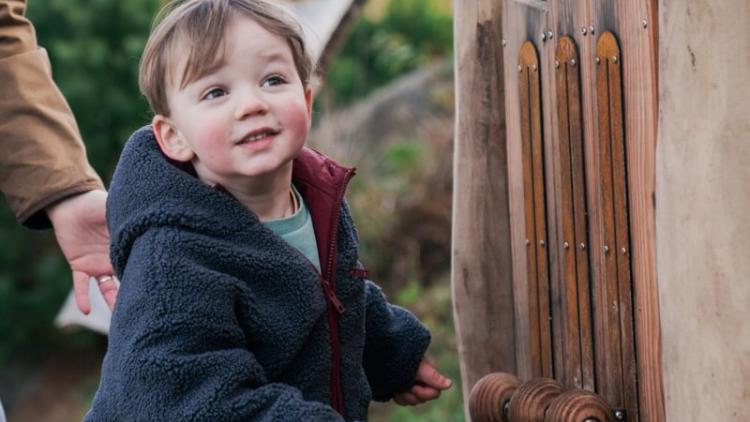 Child running next to wooden  Giant marble run