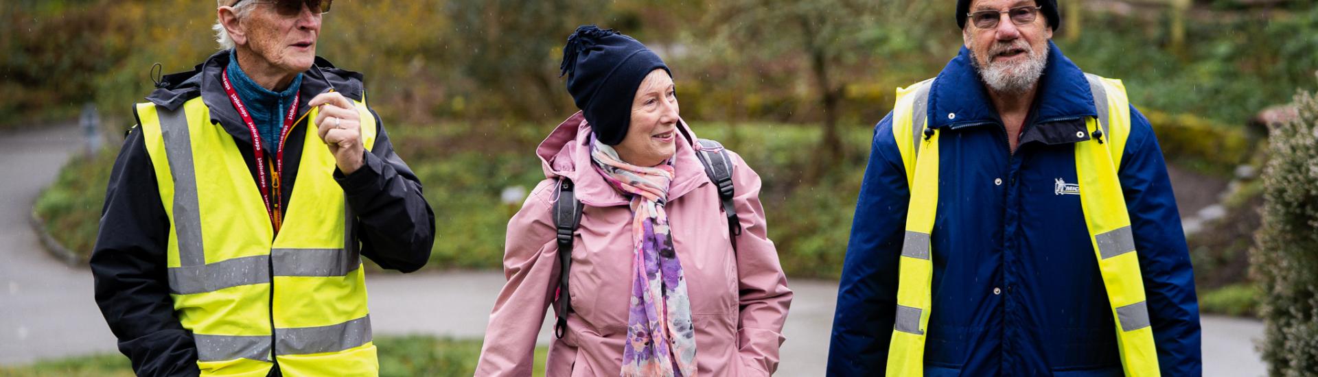 Two males and one female walking on a footpath