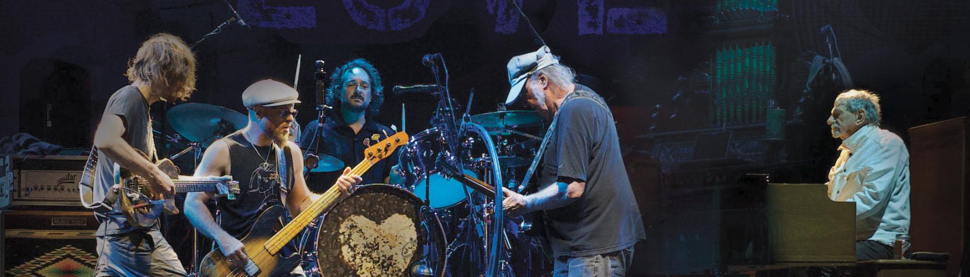 Neil Young playing on stage with his band
